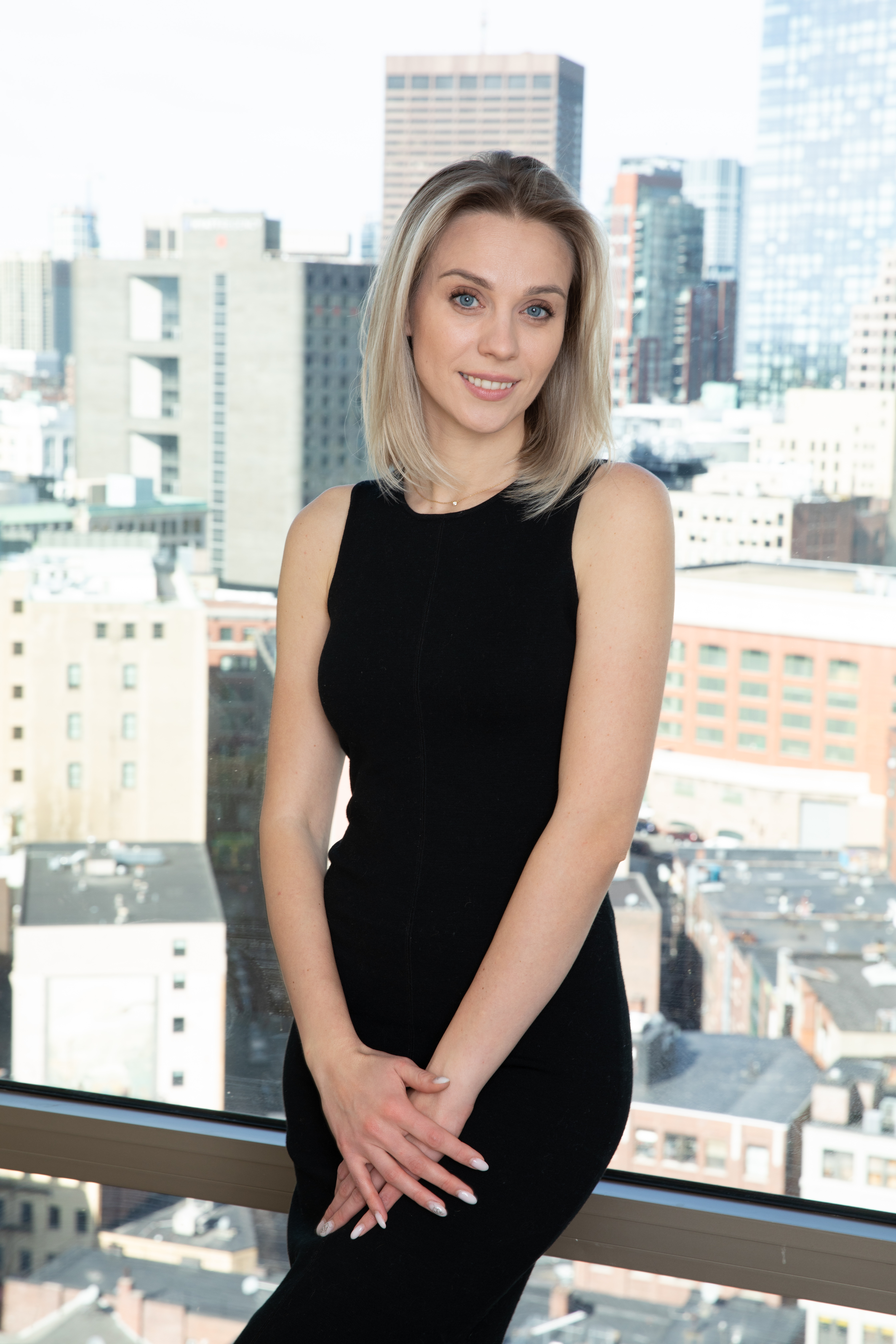 Victoria, AI Advisor, standing beside a window overlooking the city